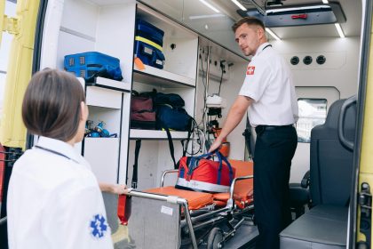 Dois paramédicos organizam suprimentos médicos dentro de uma ambulância para atendimento de emergência.