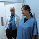 Médicos e enfermeiros conversam em um corredor de hospital.