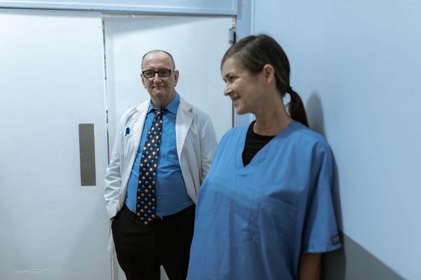 Médicos e enfermeiros conversam em um corredor de hospital.