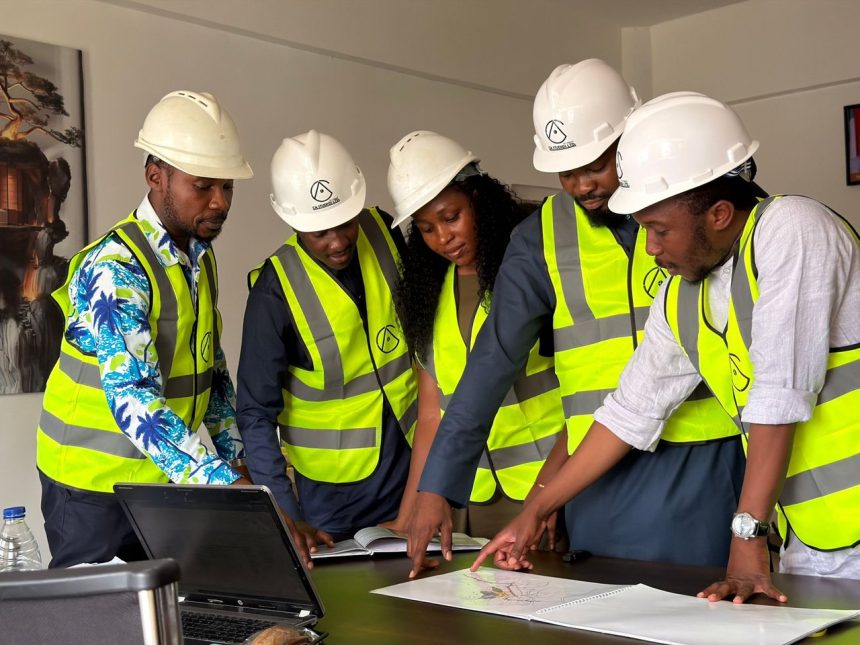 Equipe de engenheiros usando capacetes e coletes de segurança analisa plantas de um projeto de construção em ambiente interno