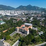 Vista aérea do estádio do Maracanã cercado pela paisagem urbana do Rio de Janeiro.