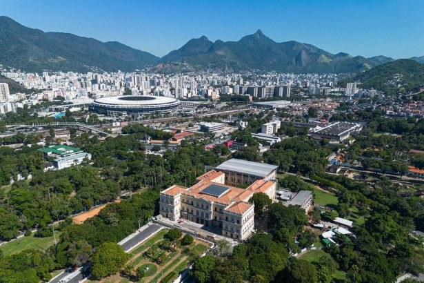 Vista aérea do estádio do Maracanã cercado pela paisagem urbana do Rio de Janeiro.