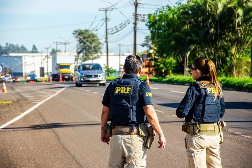 Agentes da Polícia Rodoviária Federal monitoram o tráfego em uma rodovia durante o dia.